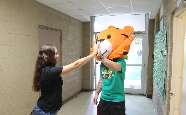 Five Points Elementary Principal Brandi Keen high fives teacher William Sheldon, who is wearing a tiger mascot head, during the school’s final walkthrough on Monday. (TONY BRITT/Lake City Reporter)