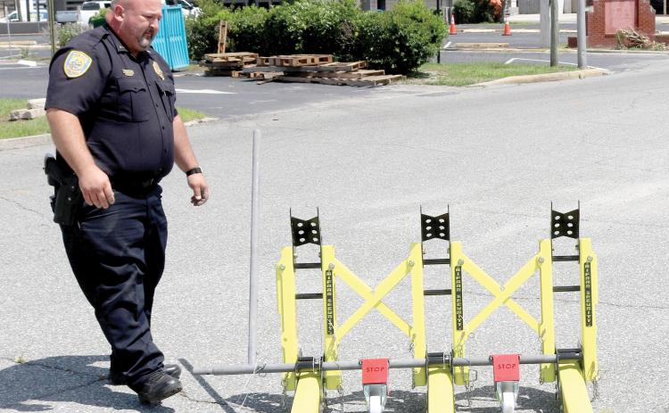 Lt. Garrett Register looks at a modular vehicle barrier on Wednesday. The Lake City Police Department used federal grant funding to obtain the barriers as a way to block off roads during events to protect pedestrians. They will be used for the first time Friday. (TONY BRITT/Lake City Reporter)