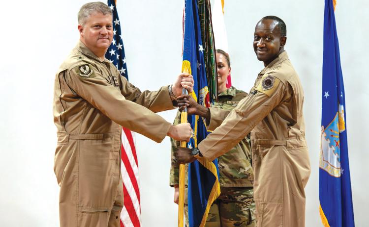 U.S. Air Force Brig. Gen. Travis Edwards, right, 379th Air Expeditionary Wing incoming commander, receives the 379th AEW guidon from Maj. Gen. David Shoemaker, 9th Air Force (Air Forces Central) deputy commander, during the 379th AEW Change of Command Ceremony within the U.S. Central Command area of responsibility, June 9, 2025. (Staff Sgt. Sean Moriarty/U.S. Air Force)