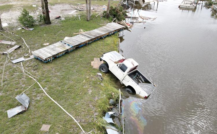 In Horseshoe Beach, near where Hurricane Idalia made landfall, a drone image shows a displaced vehicle spewing gasoline into a neighborhood canal. (MAX CHESNES/Tampa Bay Times/TNS)