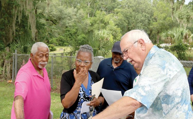 Raymond Brady (from left), Patricia Brady and Terry Harrell look on as Chuck Denmark, a trustee of Bethel Community Cemetery, uses a map to show property lines and easement for the Brady-Jones Bethel Community Cemetery. Bethel Community Cemetery trustees recently gave Brady-Jones Bethel Community Cemetery trustees a deed to the cemetery which is adjacent to Bethel Community Cemetery. (TONY BRITT/Lake City Reporter)