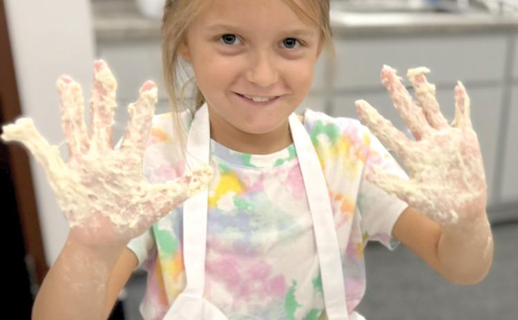 Tara Markham shows hands full of dough after mixing her first sourdough loaf. (COURTESY)