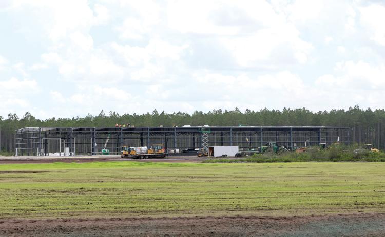 Work continued Friday on the 48,335-square-foot facility for AgroLiquid at the North Florida Mega Industrial Park. The grass parcel in front of the AgroLiquid facility is being eyed by a foreign steel manufacturer, according to county officials. (TONY BRITT/Lake City Reporter)