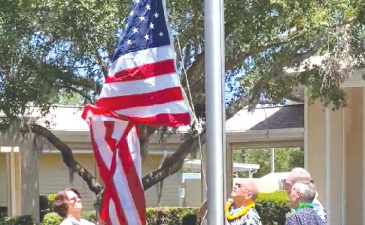 Volunteers raise the American flag outside of Haven Hospice. (COURTESY)