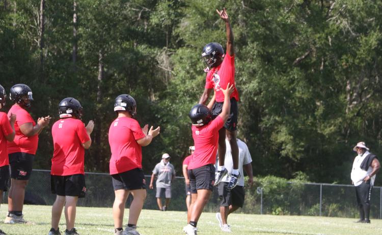 Fort White quarterback Jayden Jackson is hoisted to the air by left tackle Tayvin Fleming ahead of Monday’s practice. (MORGAN MCMULLEN/Lake City Reporter)