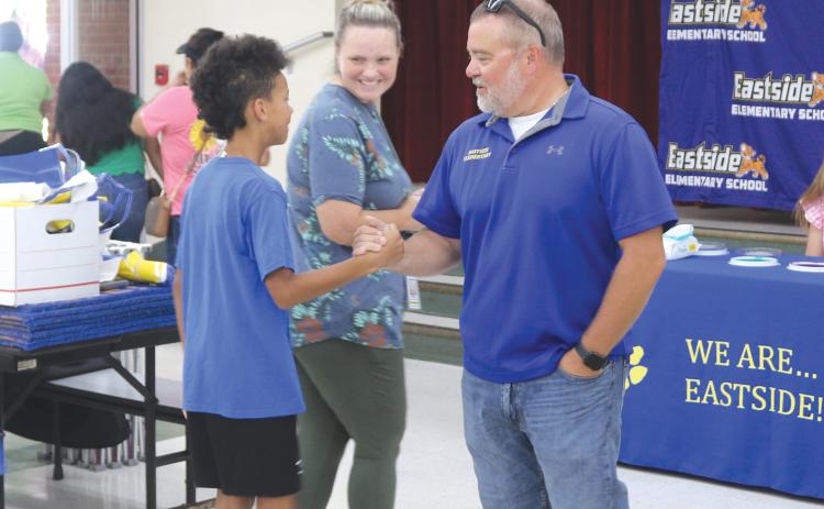 Roger Little (right), Eastside Elementary School principal, greets parents and students as they visit the temporary cafeteria on Thursday during a school Sneak Peak session. More than 100 people visited the school during the session. (TONY BRITT/Lake City Reporter)