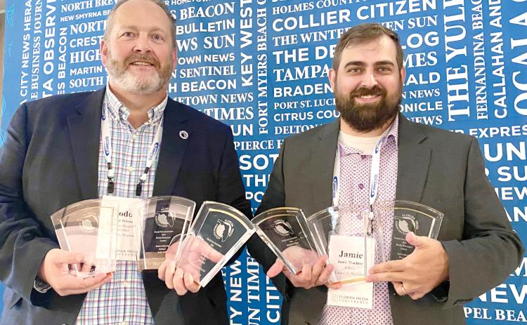 Lake City Reporter Publisher Todd Wilson (left) and Editor Jamie Wachter hold up the first-place awards that the Reporter and sister publication Nassau County Record captured last week in the Florida Press Association Weekly Newspaper Contest. (COURTESY)