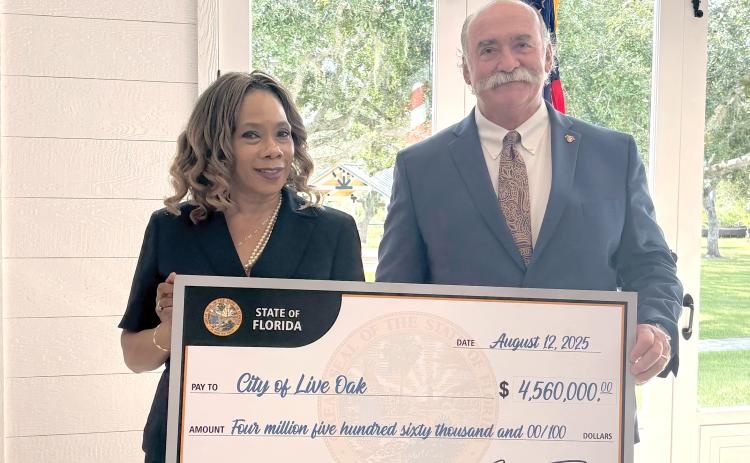 Live Oak City Manager Larry Sessions (right) and Councilwoman Vanessa Brown Robinson were in Arcadia last Thursday to receive a ceremonial $4.5 million check from the State of Florida. The funding will go toward water system improvements and home repairs for low-income families. (COURTESY)