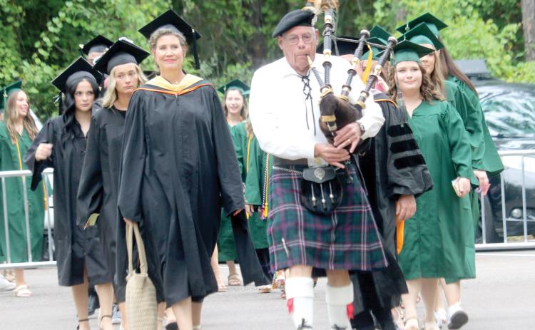 A First Coast Highlanders bagpipe player leads the procession of Florida Gateway College professors and graduation candidates into the gymnasium on Thursday evening for the school’s summer graduation ceremony. (TONY BRITT/Lake City Reporter)