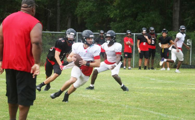 Fort White quarterback Matthew Pitts scrambles during 11-on-11s at Monday’s practice. (MORGAN MCMULLEN/Lake City Reporter)