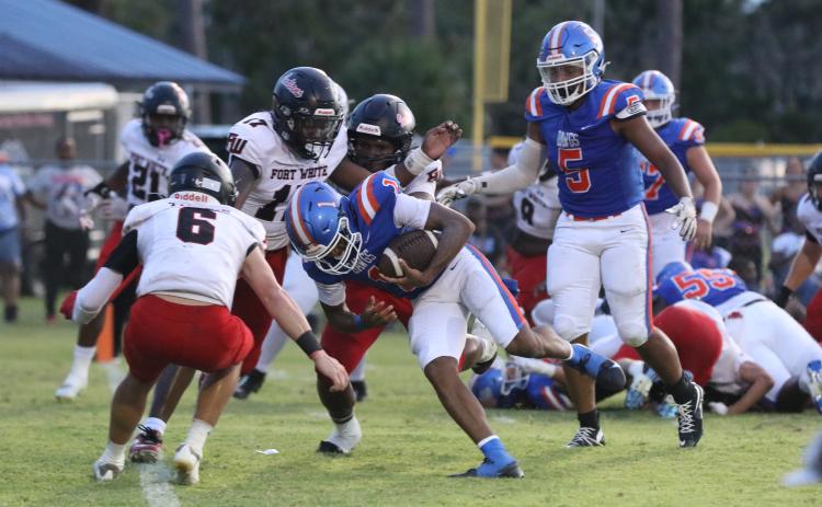 Fort White linebacker Carson Lumpkin (17) and defensive back Matthew Pitts gang up to tackle Taylor County quarterback Janez Glanton on Friday. (MORGAN MCMULLEN/Lake City Reporter)
