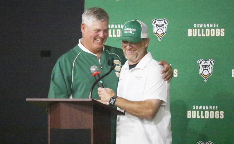 Bill Ragans (left) and Kyler Hall share a hug and a laugh during the Suwannee football 100-year celebration Friday night at the Suwannee Coliseum. (JAMIE WACHTER/Lake City Reporter)