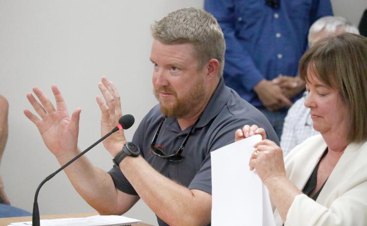 Stephen Douglas, a co-owner of Suwannee Iron Works, speaks during a public hearing Tuesday night in front of the Suwannee County Commission on the company’s request for a special exception to the county’s zoning and Land Development Regulations. Seated next to Douglas is Emily Pierce, one of the company’s attorneys. (JAMIE WACHTER/Lake City Reporter)