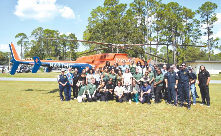 Florida Gateway College nursing students and AirLife crews pose in front of an AirLife emergency medical helicopter during last week’s demonstration. (COURTESY FLORIDA GATEWAY COLLEGE)