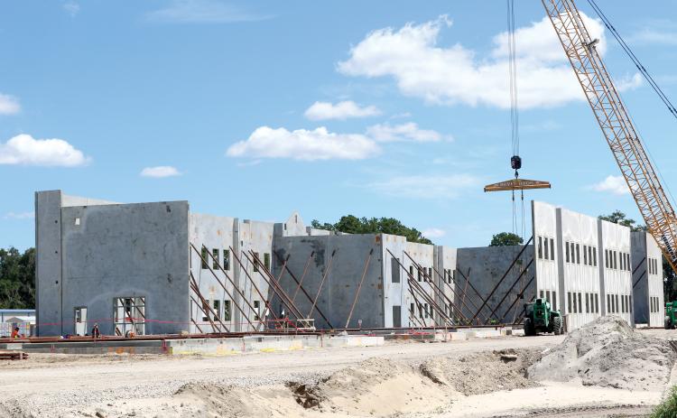 Construction crews continue progressing with the work at the new Eastside Elementary Schools with concrete walls for the first floor of the new building lifted into place this week. (TONY BRITT/Lake City Reporter)