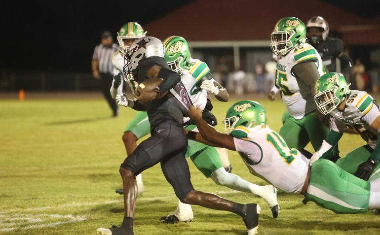 Madison County quarterback LJ Crumity pulls away from Suwannee linebacker Marco Rojas as De’aumann Jones closes in Friday night at Boot Hill. (PAUL BUCHANAN/Lake City Reporter)