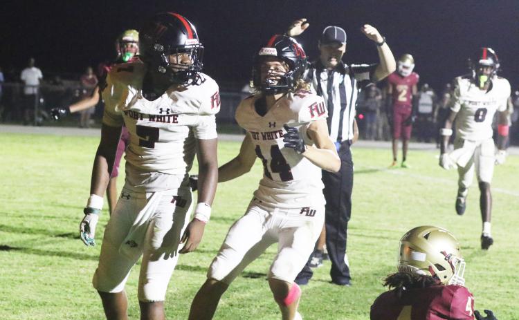 Fort White receiver Ashton Giddens (right) runs to celebrate with fellow receiver X’Zaevion Gibson after Gibson’s go-ahead 31-yard touchdown catch in Friday’s 41-40 win over North Marion. (MORGAN MCMULLEN/Lake City Reporter)