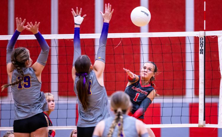 Lafayette hitter Brooke Lamb fires a shot as Columbia hitters Chloe Nickelson (19) and Ava Christie (17) on Monday. (JACK HOWDESHELL/Lake City Reporter)