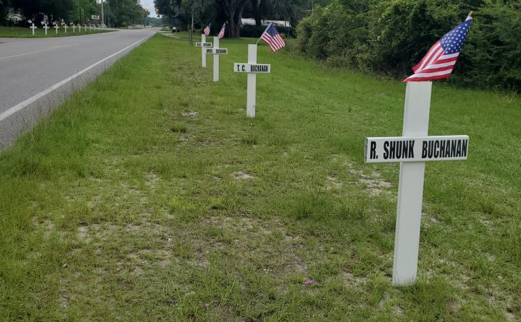 Crosses and flags line County Road 53 in Day several years ago. The crosses in honor of veterans will go up Monday there and on Tuesday by the Masonic Lodge in Mayo. (COURTESY)