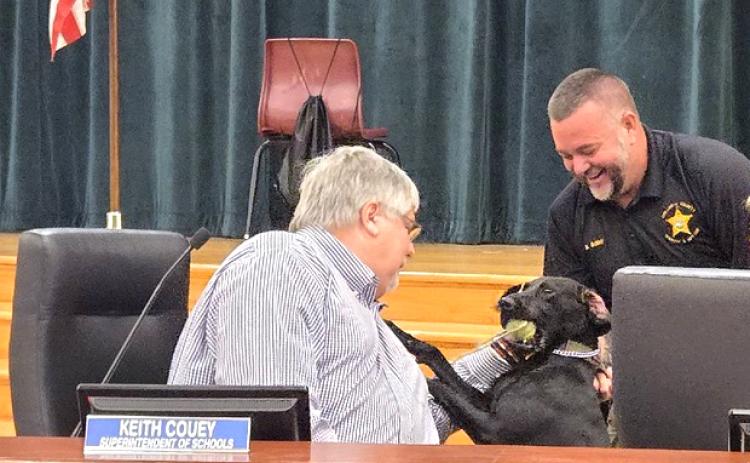 Columbia County Schools Superintendent Keith Couey (left) greets Jade as Columbia County Sheriff’s Deputy Kevin Bailey introduces her to the school board. (COURTESY COLUMBIA COUNTY SHERIFF'S OFFICE)