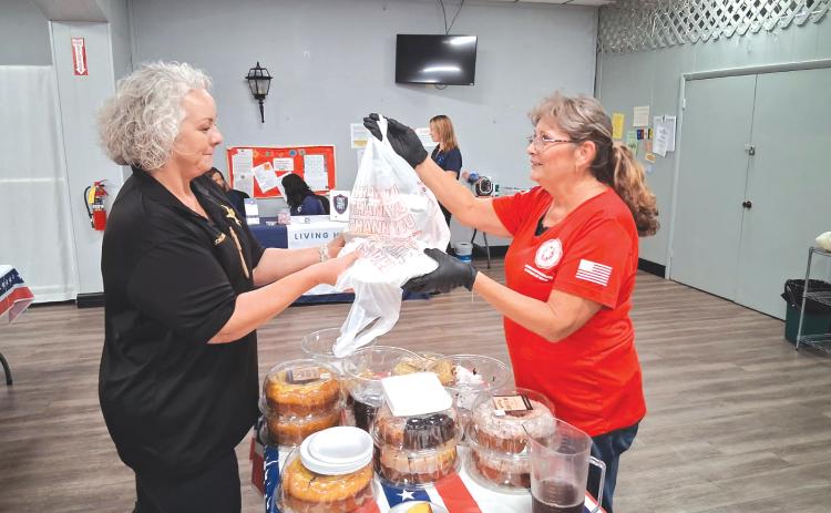 Columbia County Sheriff’s Office Maj. Katina Dicks (from left), gets a bag of to-go plates for CCSO staff from Lisa Toliver, an American Legion Auxiliary member. (TONY BRITT/Lake City Reporter)
