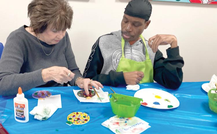 Gateway Art Gallery artist Jeanne Van Arsdall discusses design with CARC painter Tony Lovett. (COURTESY)