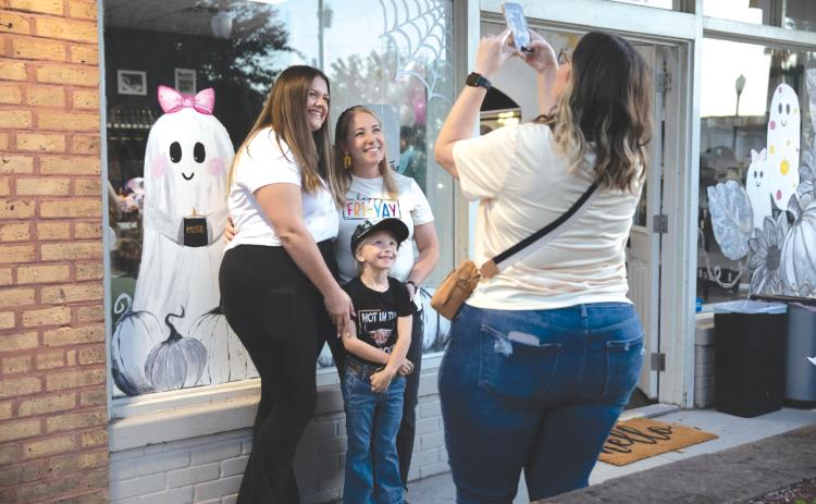 Residents pose in front of the MUSE Candle Studio storefront ahead of Friday’s Ghouls Night Out event in downtown Lake City. (COURTESY)