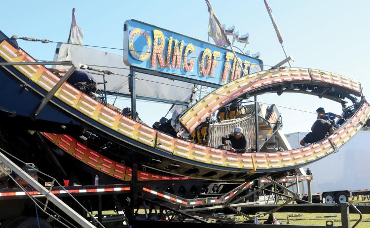 Workers get set on constructing the Ring of Fire, one of the many attractions coming this weekend as the 71st annual Florida Gateway Fair opens at the Florida Gateway Fairgrounds on Friday. (TONY BRITT/Lake City Reporter)