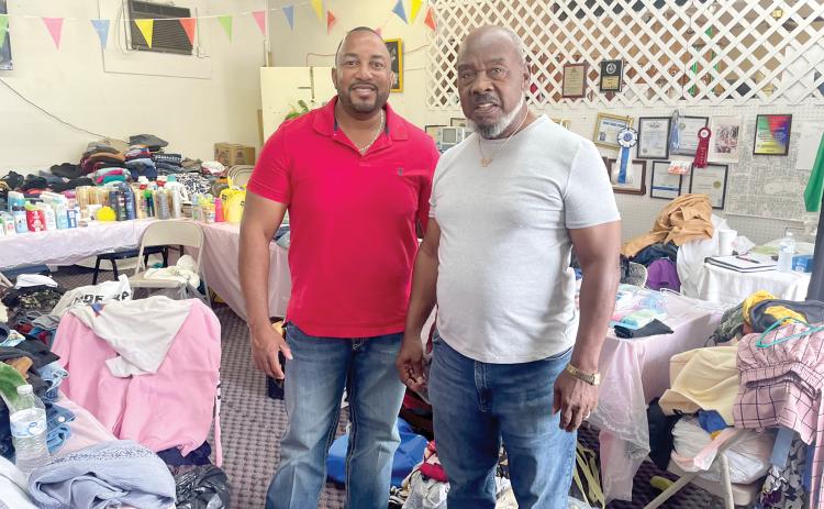 Kevin Parnell (left), Columbia County District 1 Commissioner, stands with Lester McKellum, director of the Greater Lake City Community Development Corporation, in the midst of contributions that were donated to Cedar Park Apartment complex fire victims. (COURTESY)
