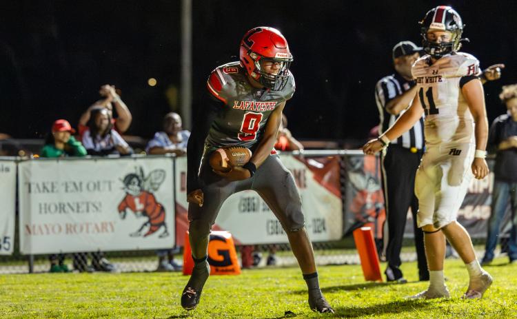 Lafayette quarterback Tywan Williamson reacts after scoring the Hornets’ first touchdown against Fort White on Friday night. (JACK HOWDESHELL/Lake City Reporter)