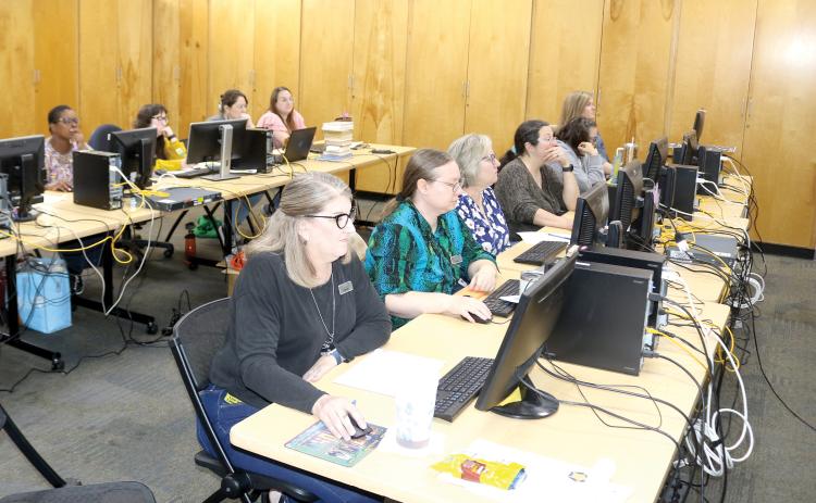 Columbia County Public Library Director Katrina Evans (left) and other library staff members sit through training in the main branch library as the library prepares to launch a new website and system. (TONY BRITT/Lake City Reporter)