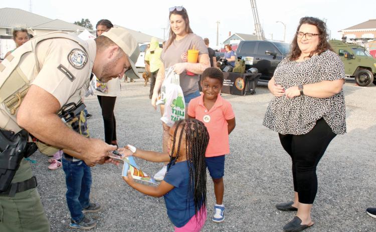 A Florida Fish and Wildlife Conservation Commission officer interacts with a child a previous National Night Out event at the Lake City Police Department. (FILE)