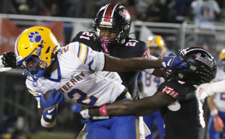 Newberry running back Kaleb Woods stiff-arms Fort White defensive back Jayden Jackson during Friday’s 25-7 loss. (MORGAN MCMULLEN/Lake City Reporter)