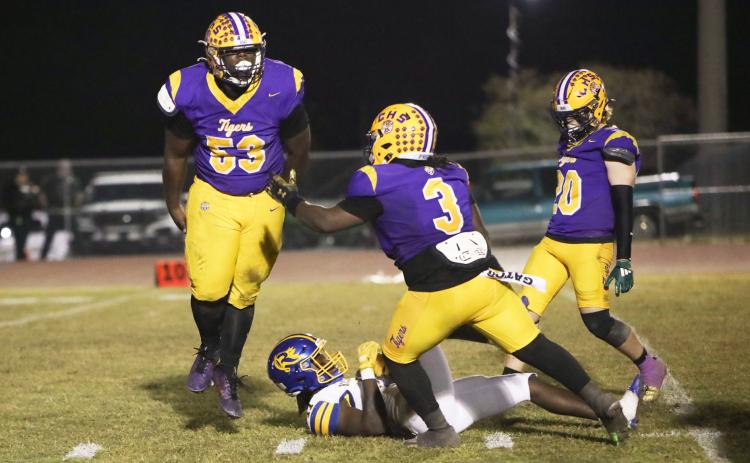 Columbia defensive tackle Jaden McCray (53) celebrates with defensive end Terry Henry (3) and linebacker Bryson Grinstead (20) after stuffing Rickards running back Karlise Price for a loss during Friday’s Region 1-4A quarterfinal. (BRENT KUYKENDALL/Lake City Reporter)
