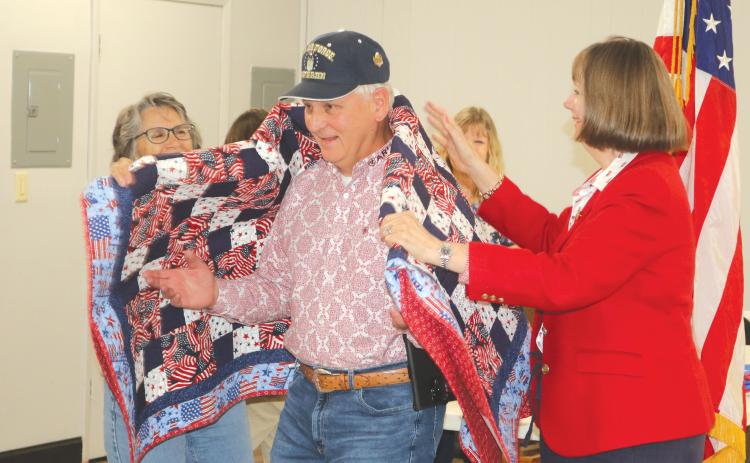 Anthony R. Hare (center) has a quilt of valor draped across his shoulders during the American Legion Post 57 Veterans Day program on Tuesday. (TONY BRITT/Lake City Reporter)