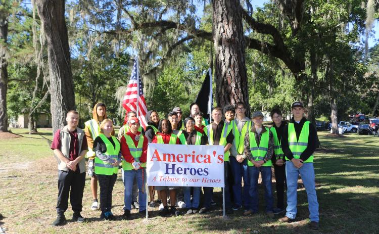 Columbia High School JROTC cadets, volunteers and chaperones pose for a picture on Saturday after helping Columbia County Republican Executive Committee members erects flags and crosses for their America’s Heroes program. (TONY BRITT/Lake City Reporter)