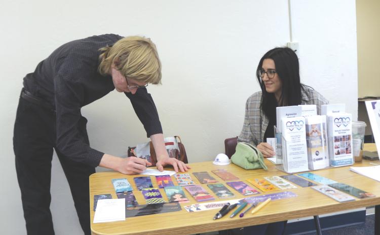 Coal Williams (left) completes information for Samantha Waldron, an employee at Another Way, during the inaugural Career Cafe. (TONY BRITT/Lake City Reporter)