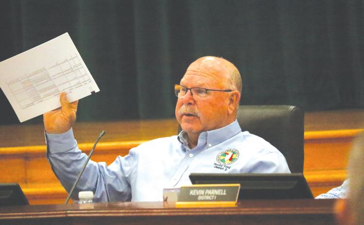 Columbia County Commissioner Rocky Ford holds up a document during the discussion about whether to renew the contract with WastePro on solid waste collection or go back out to bid. (JAMIE WACHTER/Lake City Reporter)