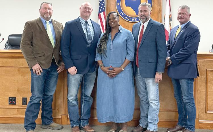 Gigi Gwinn, the widow of Donnell Gwinn, is pictured with Suwannee County Commissioners Leo Mobley (from left), Don Hale, Chairman Travis Land and Franklin White after they passed a proclamation in her late husband’s honor. The county also plans to name a new building at the fairgrounds after Donnell Gwinn. (JAMIE WACHTER/Lake City Reporter)