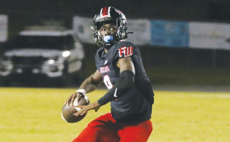 Fort White quarterback Jayden Jackson rolls out to pass during Friday’s win over Baker County. (MORGAN MCMULLEN/Lake City Reporter)