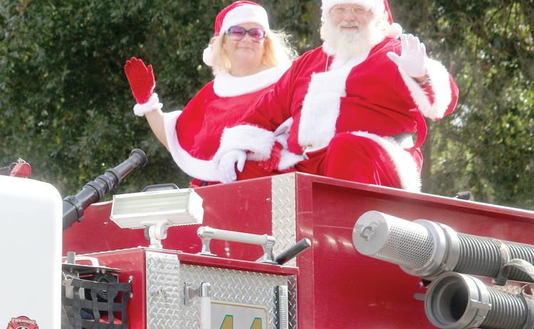 Santa and Mrs. Claus wave from a Columbia County Fire Rescue truck during last year’s Fort White Christmas parade. (FILE)