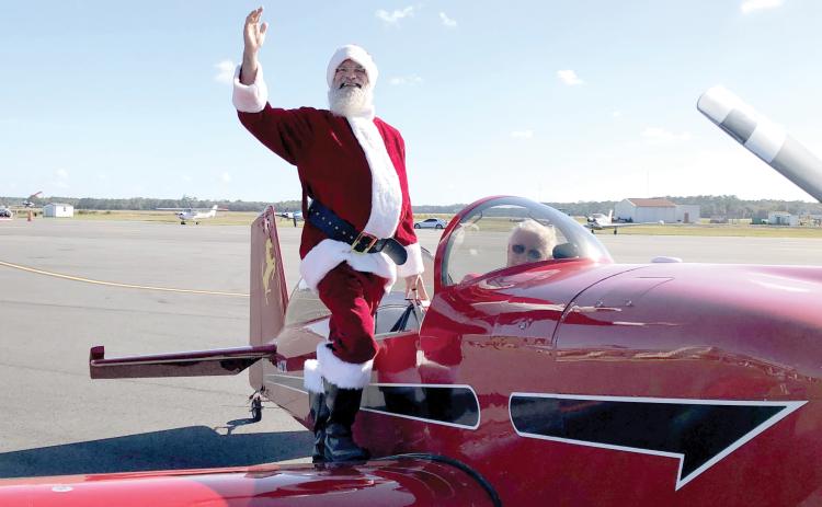 Santa Claus waves after landing in an airplane at the Lake City Gateway Airport for the inaugural Pilots With Presents Fly-In in 2023. (FILE)