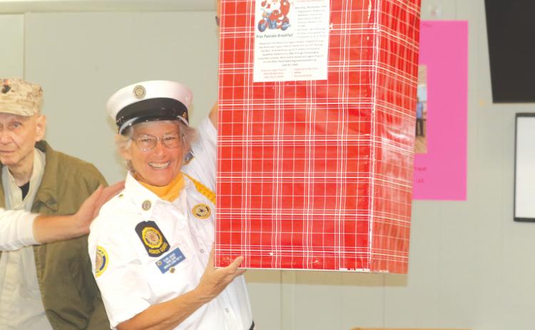 Elaine Lagasse, a member of the American Legion Post 57 Honor Guard, displays a collection box for the upcoming charity ride that scheduled to take place on Saturday. (TONY BRITT/Lake City Reporter)