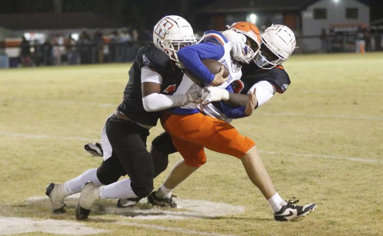 Branford quarterback Trent Land gets his facemask pulled by a Hawthorne defender during Friday night’s Class Rural quarterfinal. (JAMIE WACHTER/Lake City Reporter)