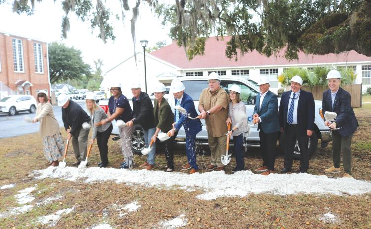 Tossing dirt to celebrate the construction of a new private fiber network for the school district were: Cindy Forsyth (from left), Jay Duval, Denise Weybrew, Hope Jernigan, Todd Widergren, Dana Brady-Giddens, Patrick Mitchell, Keith Couey, Cherry Hill, Jesus Pena, Billy Merchant and Oliver Landow. (TONY BRITT/Lake City Reporter)