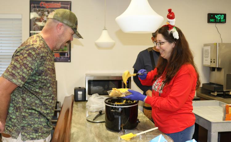 Matthew Isaacs (left), a U.S. Coast Guard veteran, gets a bowl of nachos and cheese from Karen Kraszewski, a recreational aide on Saturday at the Robert H. Jenkins Jr. Domiciliary where veterans watched the Army-Navy football game. (TONY BRITT/Lake City Reporter)