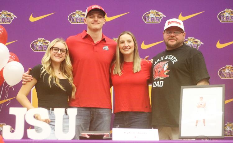 Columbia defensive end Kyten Davis (middle left) stands on stage alongside his family during his signing ceremony to attend Jacksonville State on Friday. (JORDAN KROEGER/Lake City Reporter)
