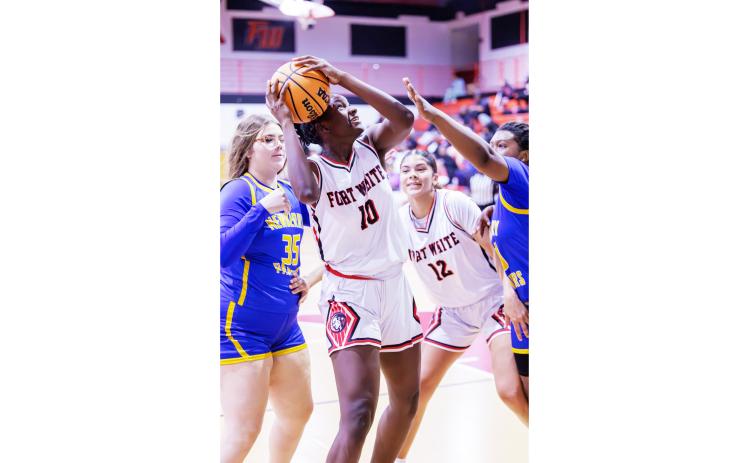 Fort White forward Jahlaya Wilson struggles to get a shot off while surrounded by the Newberry defense on Friday. (JACK HOWDESHELL/Lake City Reporter)