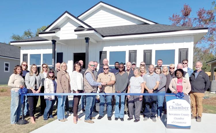 Milton Smith and Darren Webb with GSMS Developers cut the ribbon in front of one of the new houses in the Canyon Vistas subdivision in Live Oak. GSMS evelopers was joined at the ribbon cutting by Suwannee County Chamber of Commerce represenatatives as well as Suwannee County and City of Live Oak officials. (MONJA SLATER/Lake City Reporter)