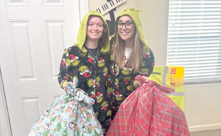 Taylor and Kayli McCathern hold bags of presents that God’s Hidden Angels collected for underprivileged children in Suwannee County. (COURTESY)